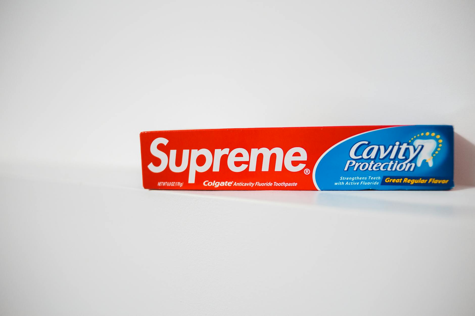 Czerwone i niebieskie pudełko pasty do zębów na białym tle