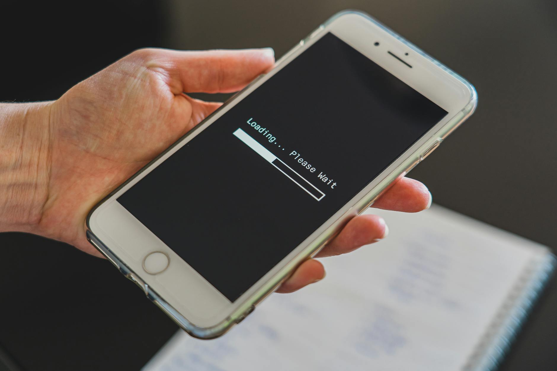 Dłoń trzymająca smartfon z zaciętym ekranem ładowania internetu