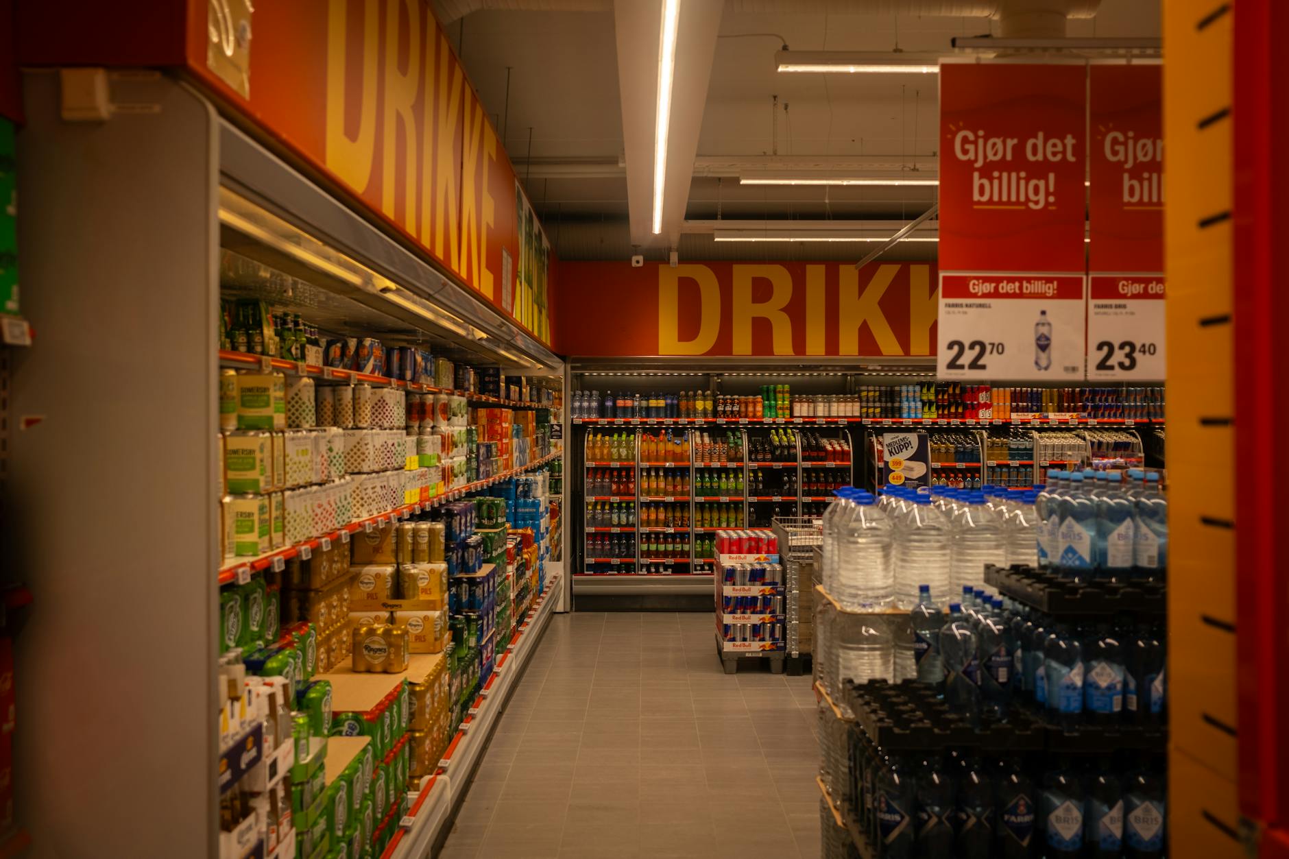 Kolorowa alejka z napojami w supermarkecie z promocjami na półkach