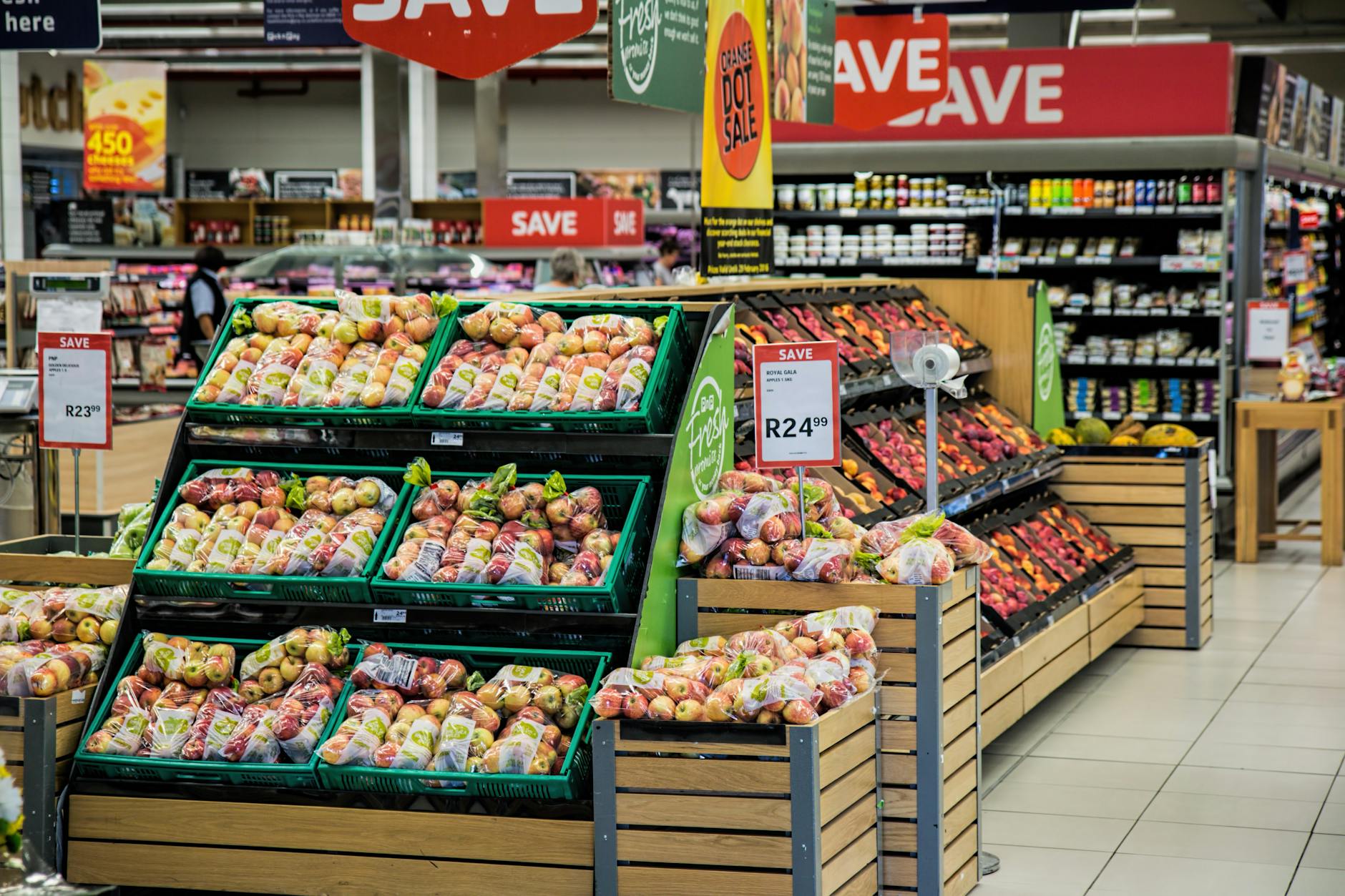 Stoisko z kolorowymi jabłkami w supermarkecie z widocznymi promocjami