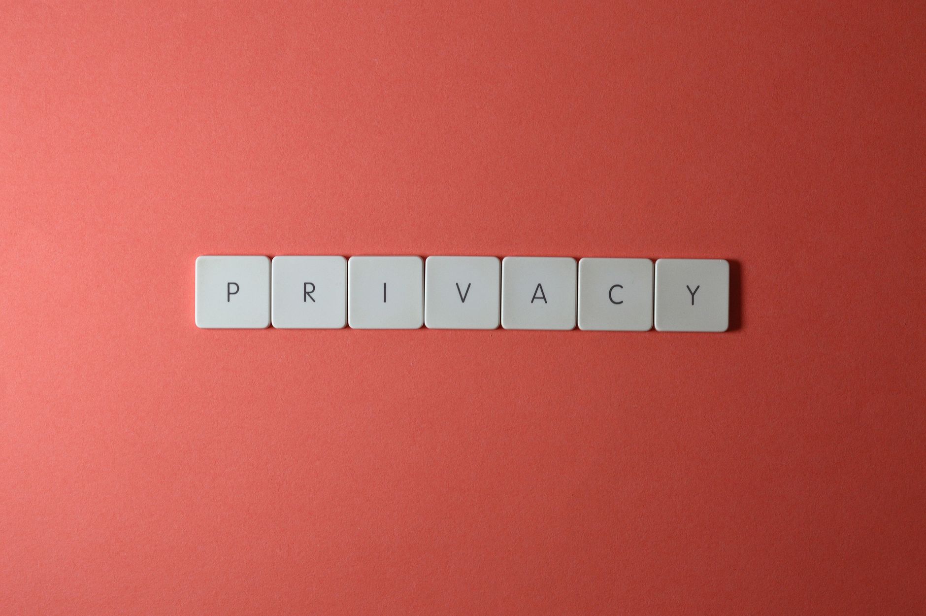 Białe kostki z napisem privacy na czerwonym tle, symbol ochrony danych